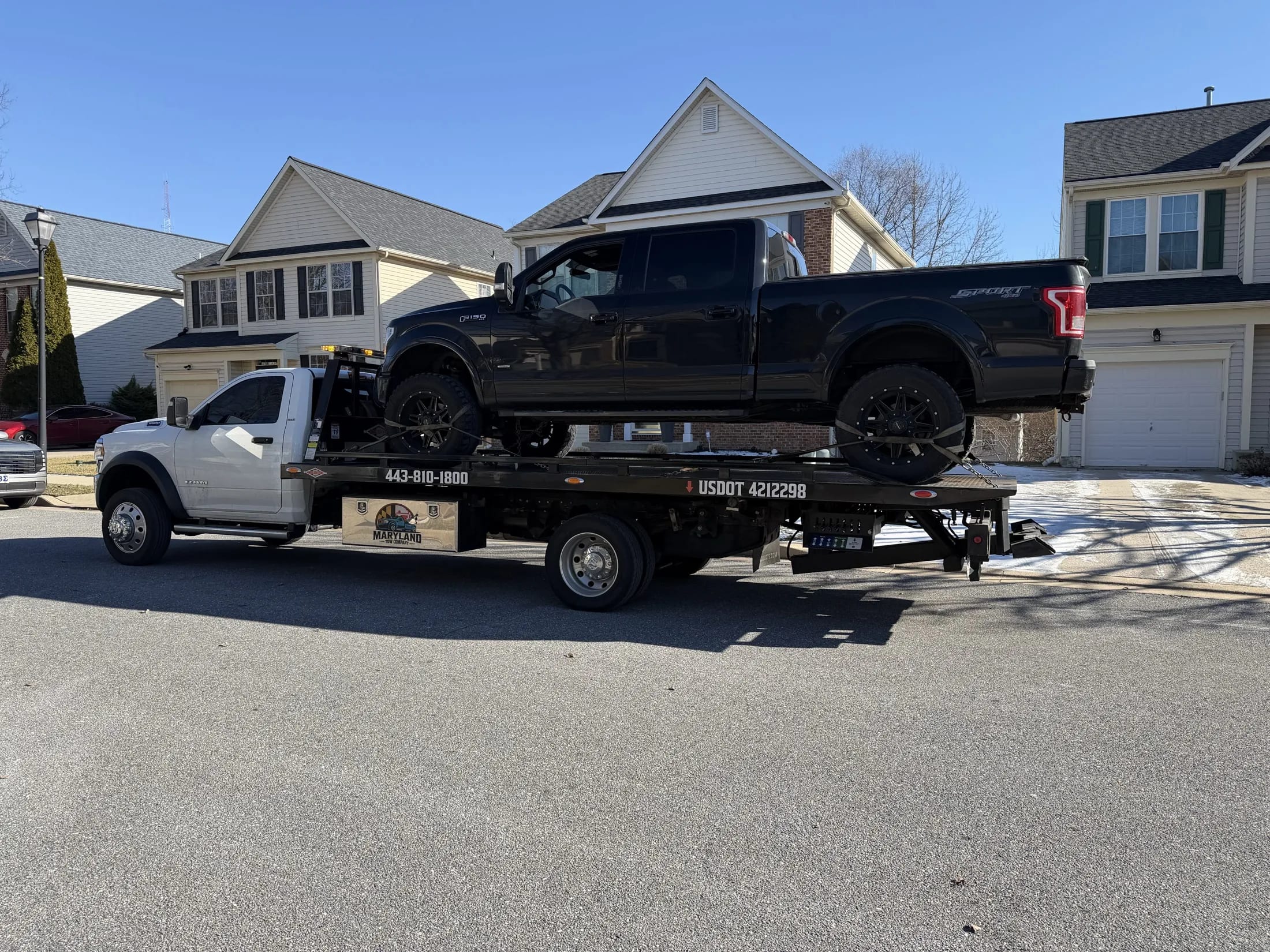 Maryland Tow Company flatbed towing a pickup truck in Maryland